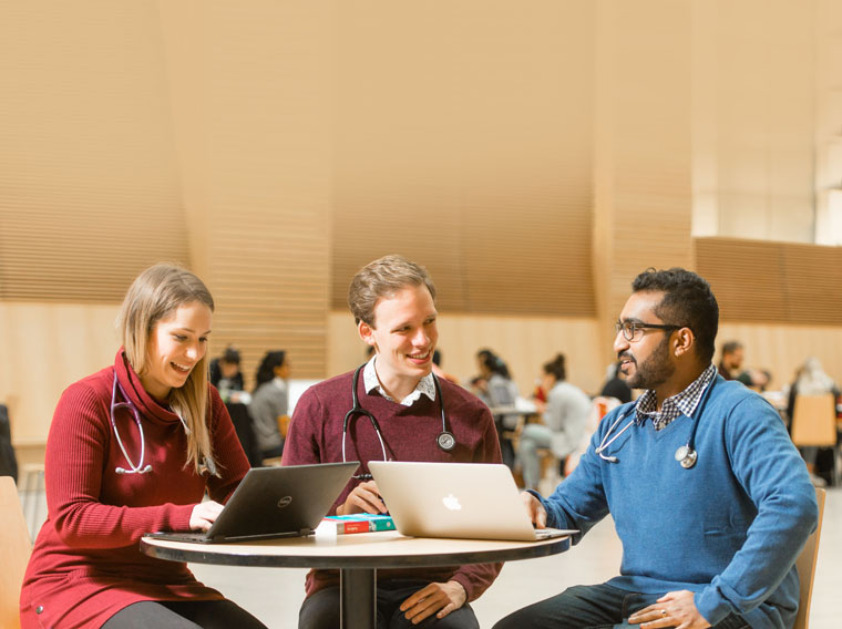 Three students sitting at a table in the Life Sciences Centre